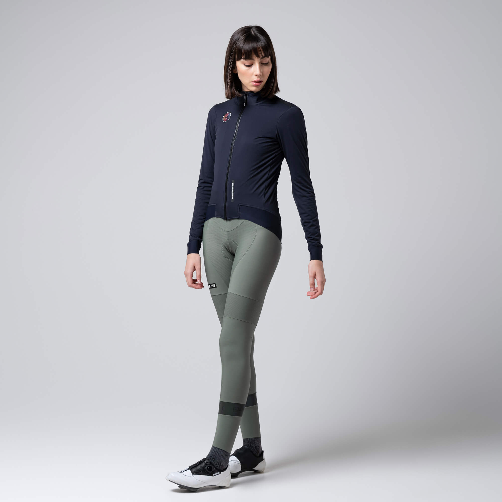 Woman wearing GOBIK Armour 2.0 Thermal Jacket - Unisex in black with full zip and fitted design against light background
