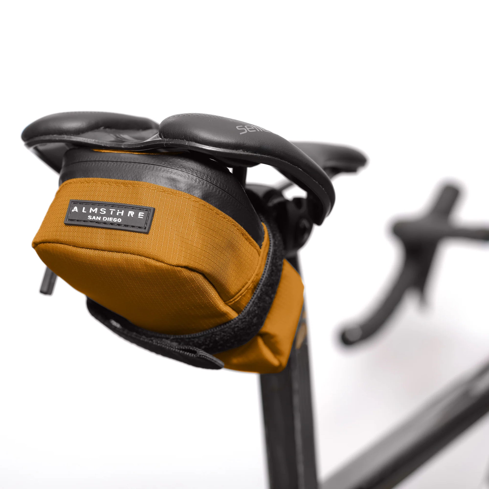 ALMSTHRE Signature Saddle Bag mounted under bike seat with adjustable strap and durable yellow fabric design