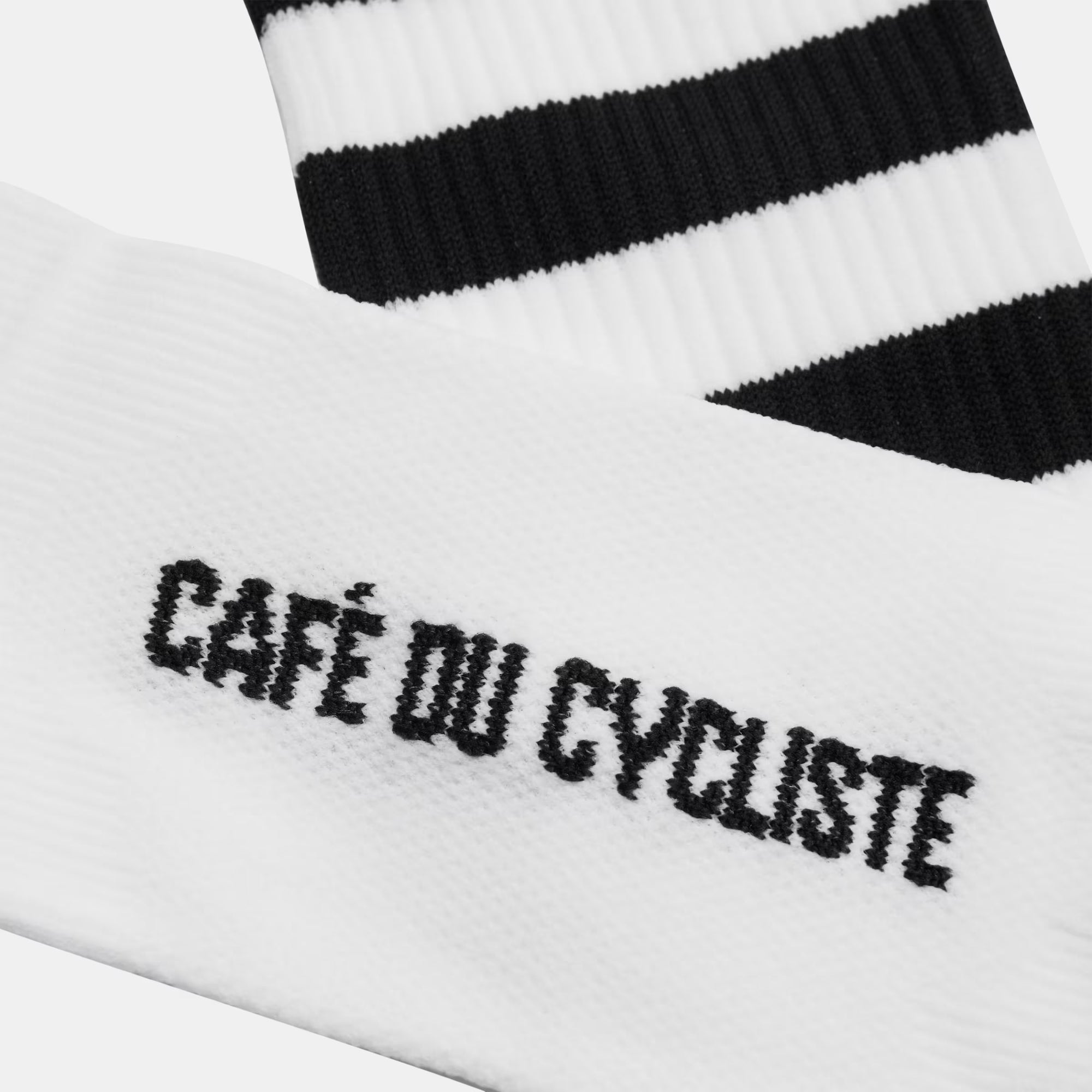 Close-up of Cafe du Cycliste Skate Socks - Black on White showing black logo on white fabric and black stripes on the cuff