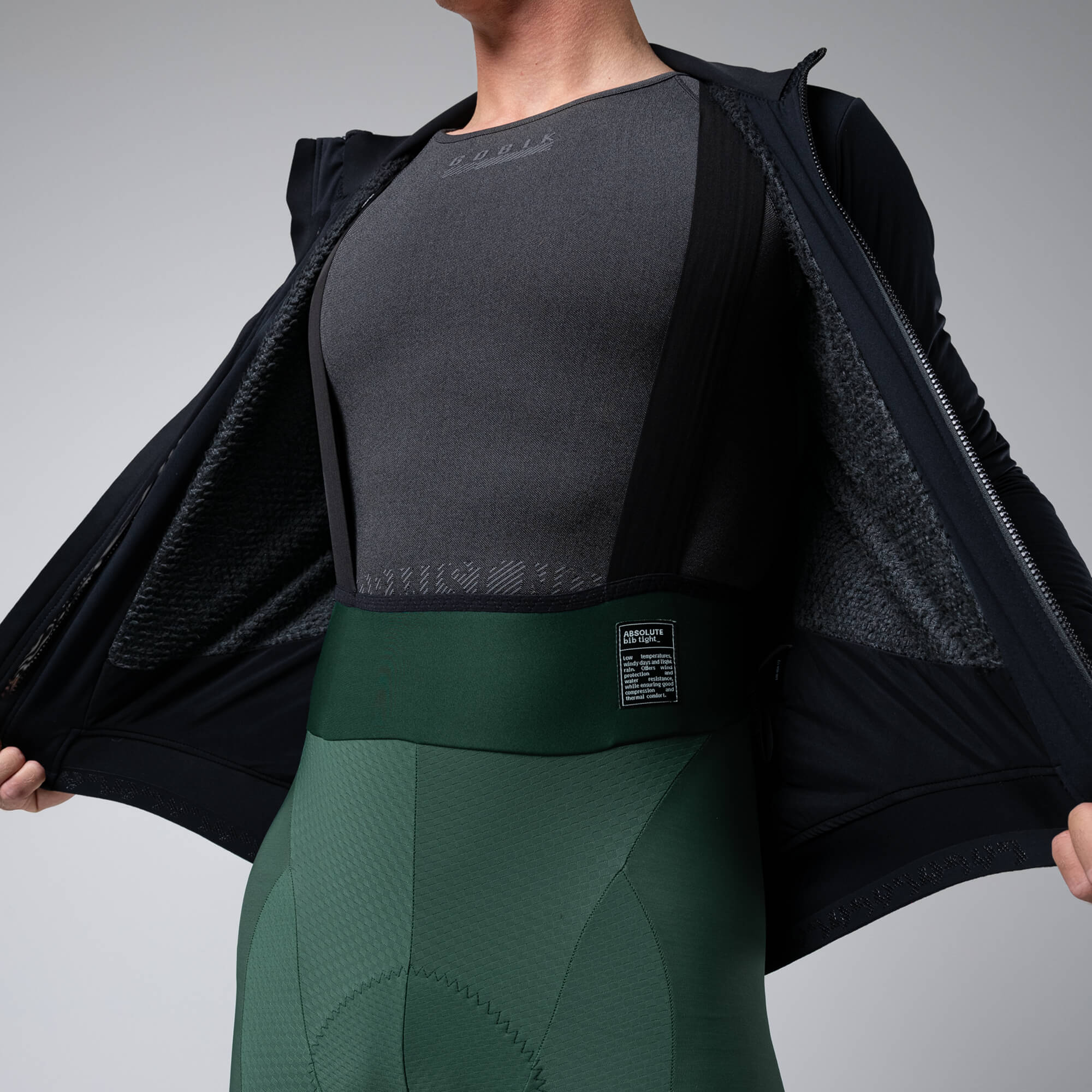 Close-up of person opening black GOBIK Armour 2.0 Thermal Jacket - Unisex to show textured inner lining and fit