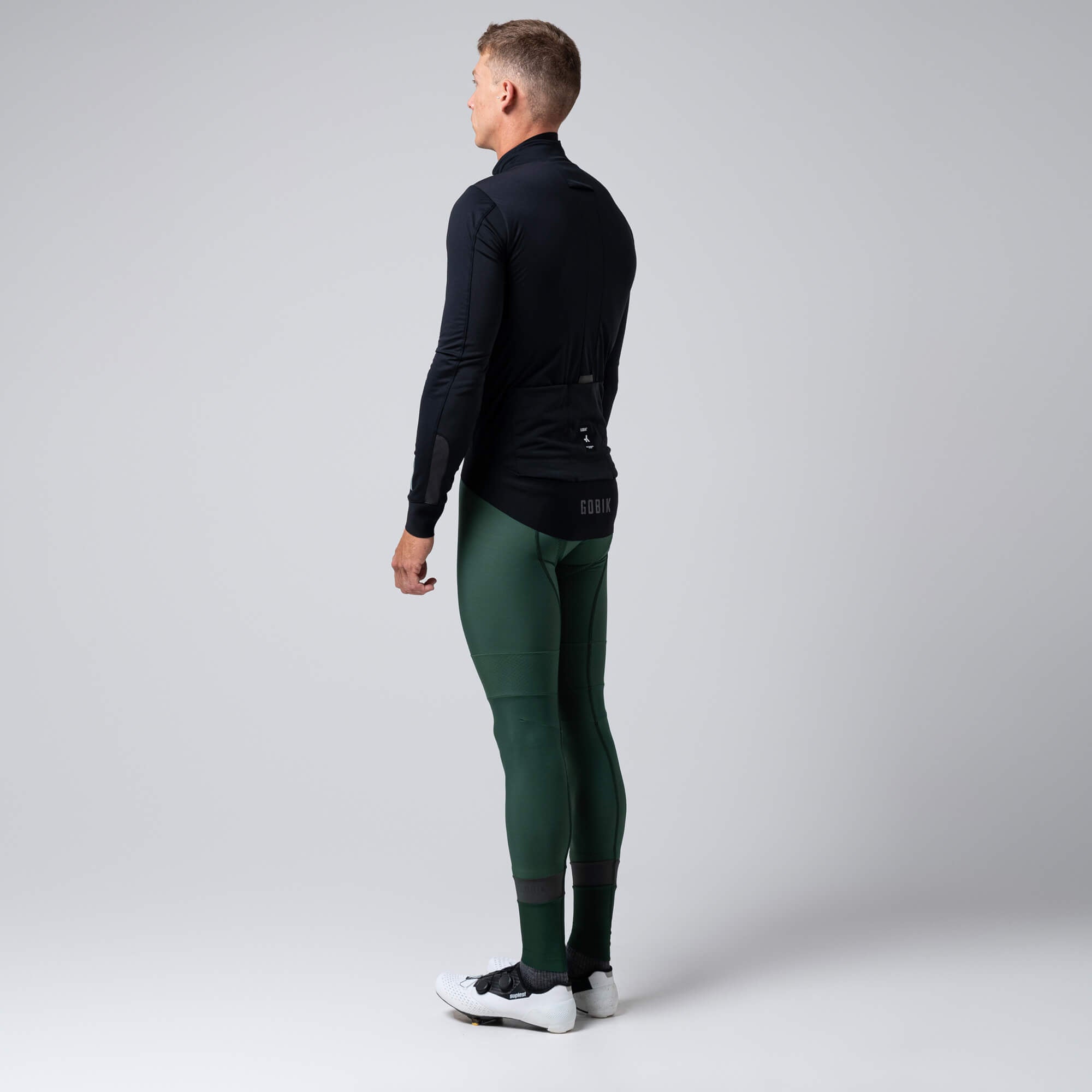Back view of man wearing GOBIK Armour 2.0 Thermal Jacket - Unisex with long sleeves and rear pockets against gray background