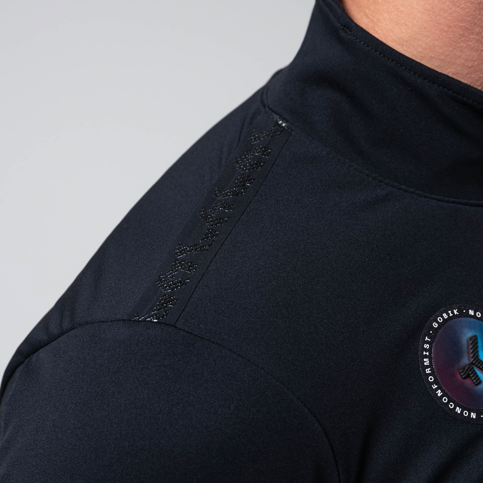 Close-up of GOBIK Armour 2.0 Thermal Jacket - Unisex showing shoulder detail and high collar in black fabric