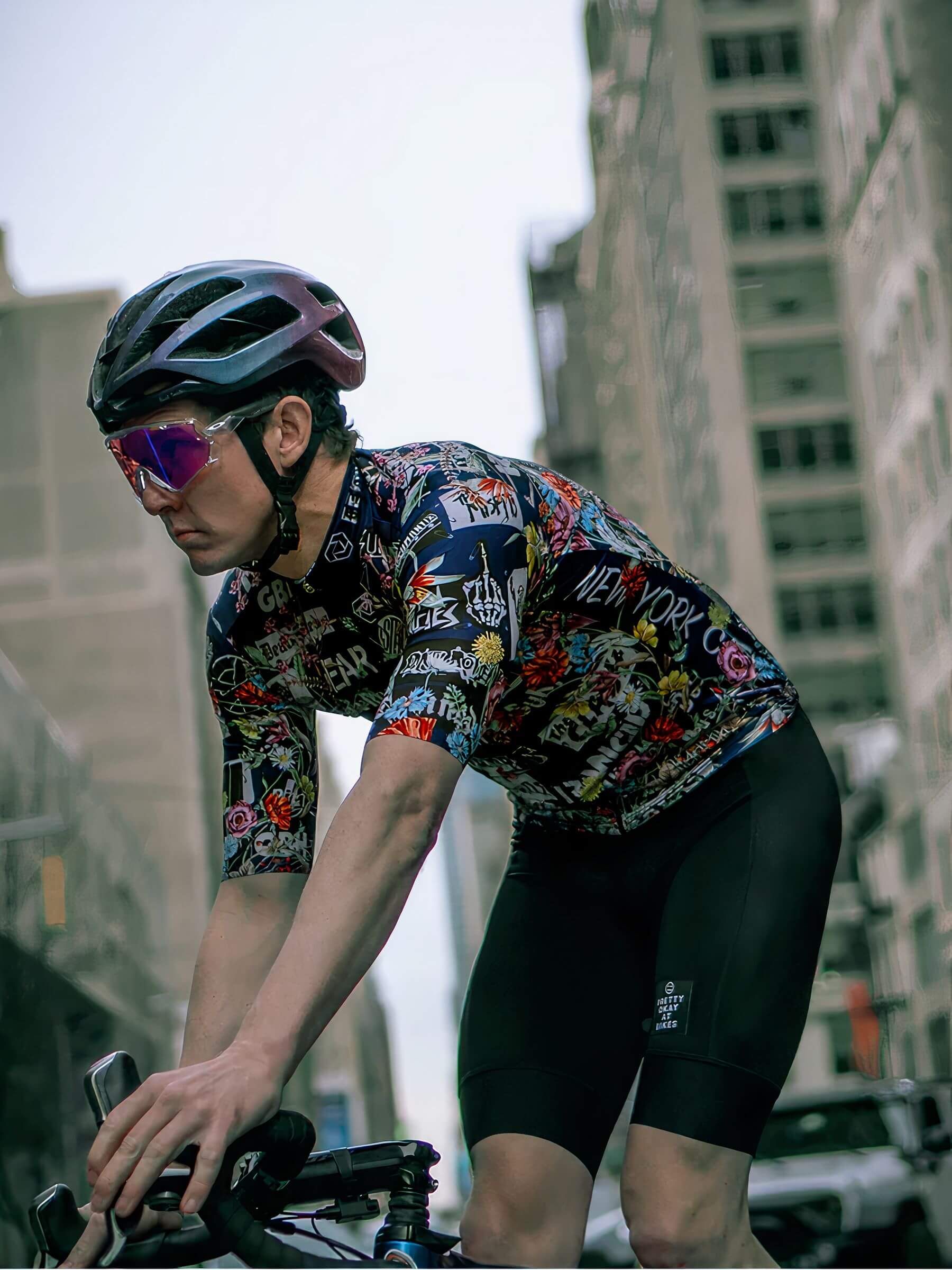 Male cyclist wearing Ostroy Punk Flowers Jersey - Men's with punk and floral design in urban setting on bike