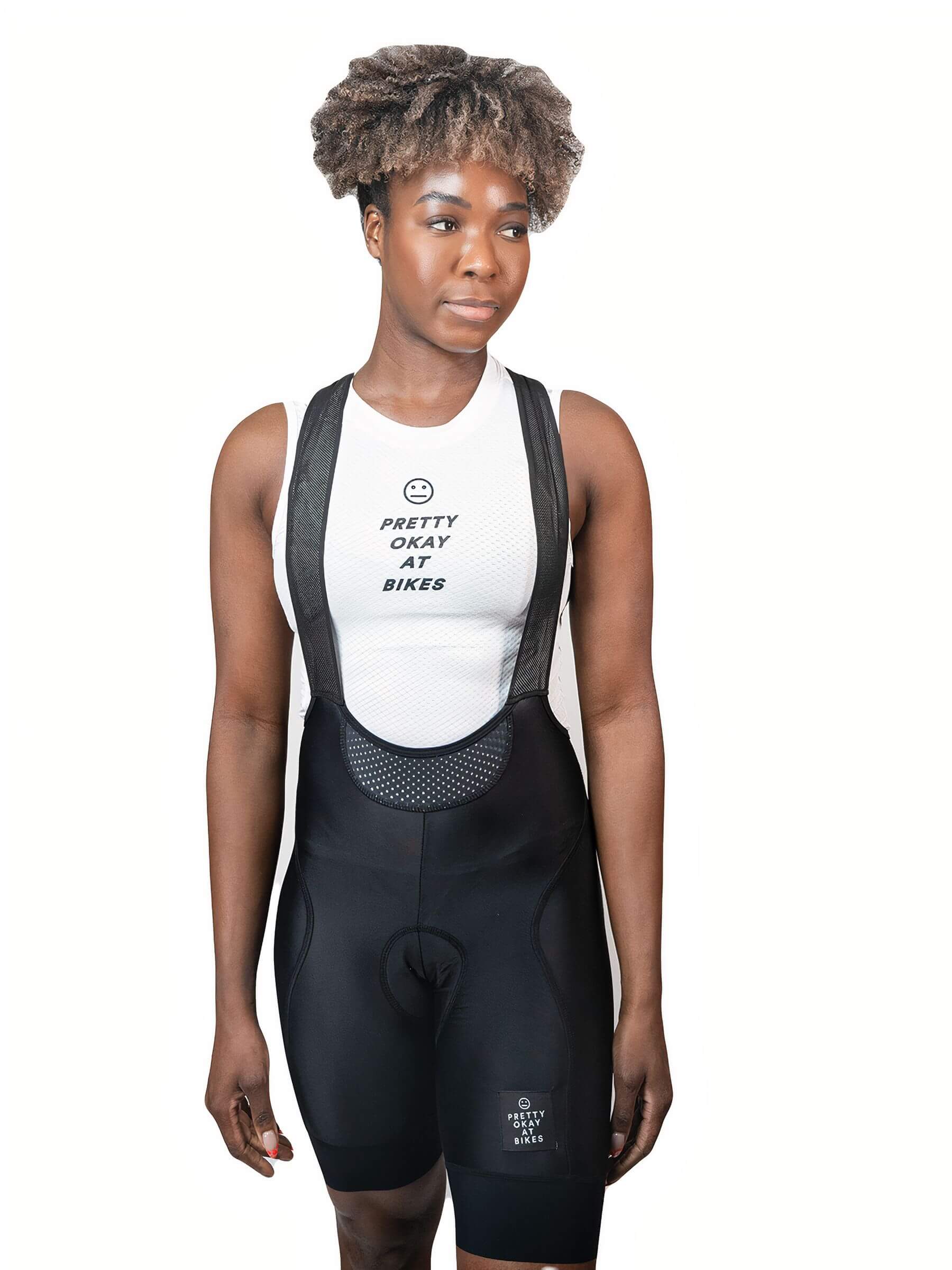Woman wearing Ostroy NoMad Bibs - Women's with black bib shorts and mesh upper panel against white background