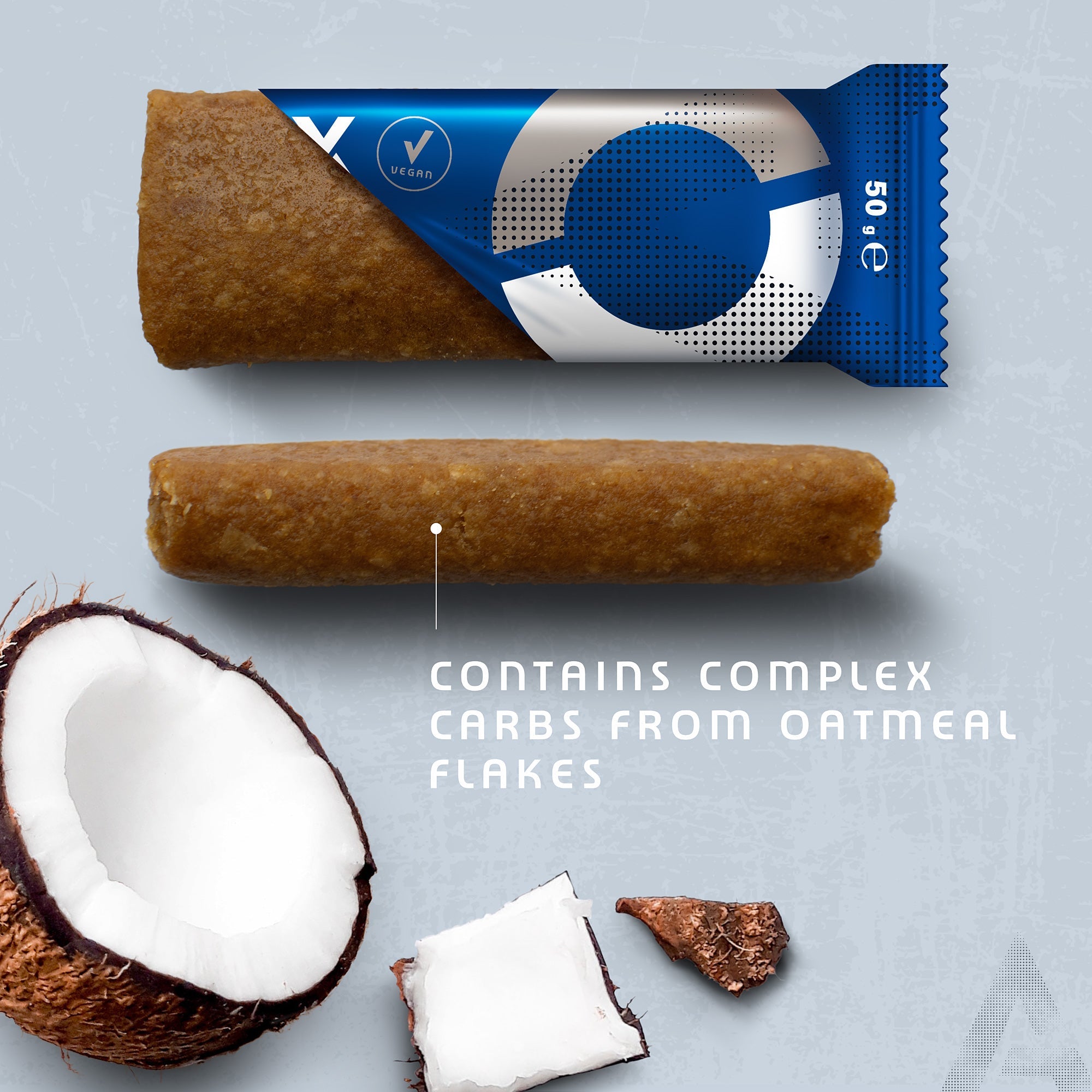 Amacx Energy Oat Bar Coconut with a bite taken, showing texture beside coconut pieces on gray background.