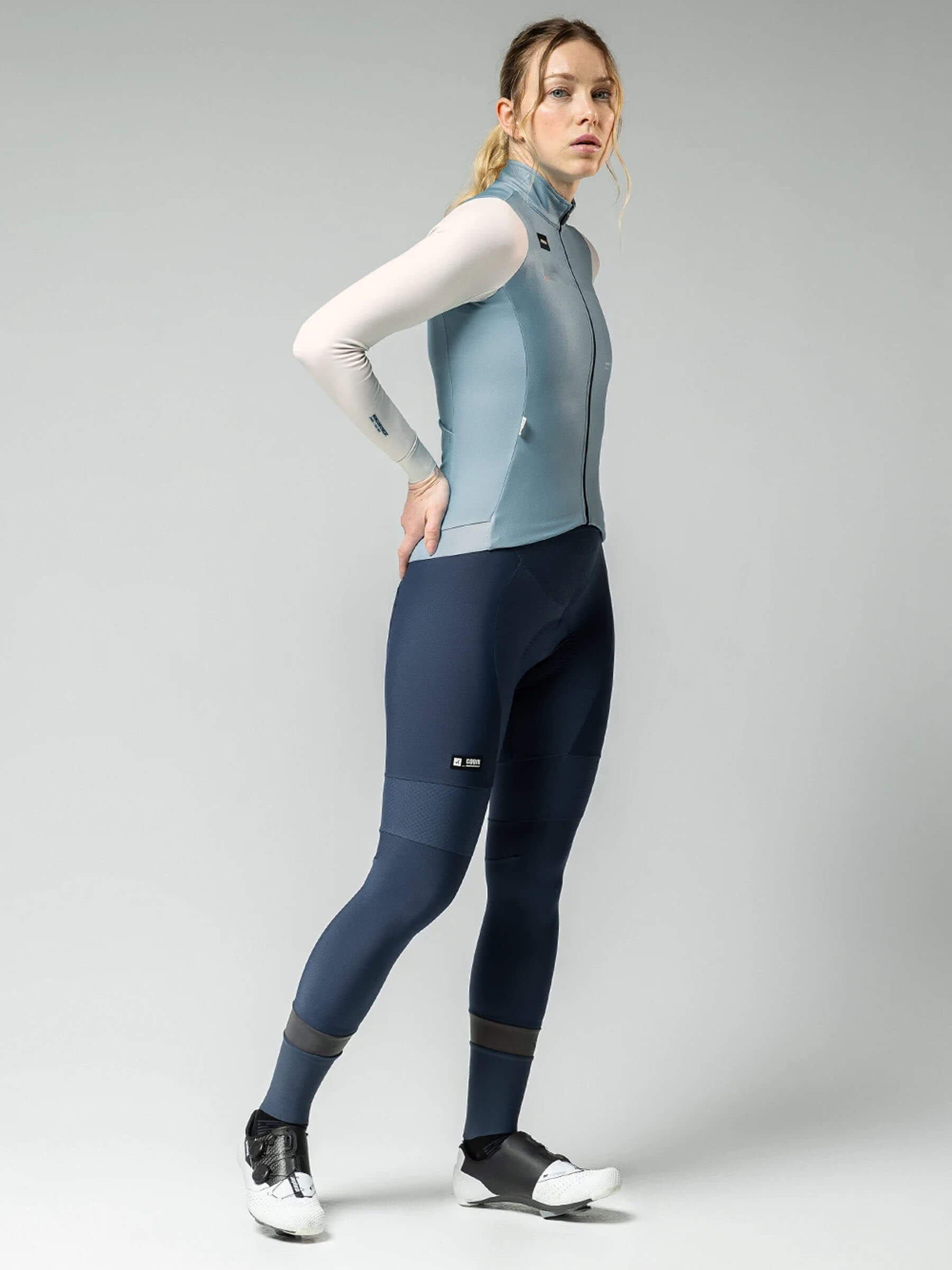 Woman wearing GOBIK Superhyder Long Sleeve Jersey - Women's in light blue with full-zip and slim fit against gray background
