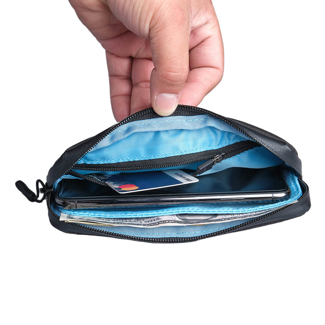 Hand holding open ALMSTHRE Ride Wallet showing organized interior with card, phone, and cash compartments